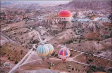  ?? BEHCET ALKAN / GETTY IMAGES ?? Hot-air balloons carry tourists as they glide over Cappadocia region in Nevsehir, Turkey in September 2020.