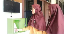  ??  ?? ONLINE: Shakila Dascha (kiri) dan Aulia Friya Rahana melakukan presensi sebelum pulang sekolah kemarin.