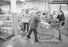  ?? Jay Janner / Associated Press ?? Customers get water bottles at Costco in southwest Austin during a citywide boil water notice caused by flooding. Estimates of the time run from a handful of days to two weeks.