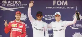  ??  ?? SHANGHAI: Mercedes driver Lewis Hamilton, center, of Britain waves with Ferrari driver Sebastian Vettel, left, of Germany and teammate Valtteri Bottas of Finland after taking pole position for the Chinese Formula One Grand Prix at the Shanghai...