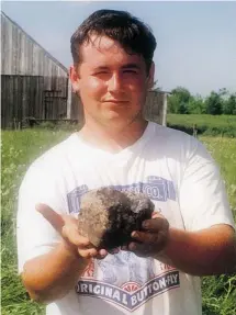  ??  ?? Stephane Forcier holds the meteorite that fell on the family farm near St-Robert, Que., in 1994. The federal government paid $10,000 for it.