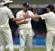  ??  ?? GOT HIM: Anderson (centre) is hailed by Stuart Broad and Liam Dawson after taking the wicket of South Africa’s Quinton de Kock