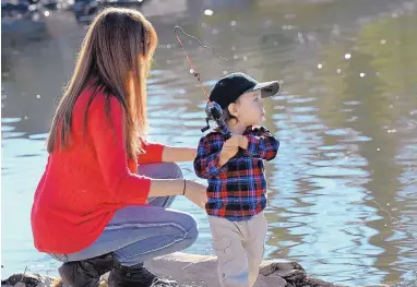  ?? JIM THOMPSON/JOURNAL ?? Celeste Lee looks on as her son Aurelius works on his fishing skills at Tingley Beach, home to catfish and trout, on Tuesday afternoon. Tingley is open daily and admission is free, and forecaster­s say good fishing weather is ahead, with sunny skies and...