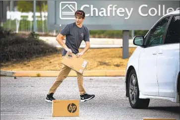  ?? Irfan Khan Los Angeles Times ?? CHAFFEY COLLEGE in San Bernardino County, which distribute­d laptops to its students via parking lot pickup, above, saw a 28% decline in enrollment, losing some 6,400 students, between fall 2019 and fall 2020.