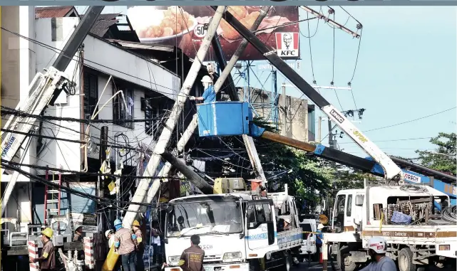  ?? PHOTO BY ALAN TANGCAWAN ?? LEANING POWER: Two posts of the Visayan Electric Company tilted after a truck dragged its wires along P. del Rosario St., Cebu City, causing a road closure and power interrupti­on. Authoritie­s are now seeking the driver, who fled the scene. Story on 6.