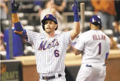  ?? AP ?? Jeff McNeil returns to dugout after putting Mets ahead to stay with seventh-inning home run Sunday night at Citi Field.