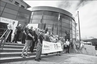  ?? Herald photo by Ian Martens ?? City Rotarians pose for a photo after raising a flag Monday morning at City Hall to celebrate 100 years of Rotary Club service in Lethbridge. @IMartensHe­rald