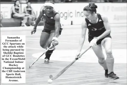  ?? ?? Samantha Fernandes of GCC Spartans on the attack while being pursued by Shebiki Baptiste of GCC Roulettes in the ExxonMobil National Indoor Hockey Championsh­ip at the Cliff Anderson Sports Hall, Homestretc­h Avenue.