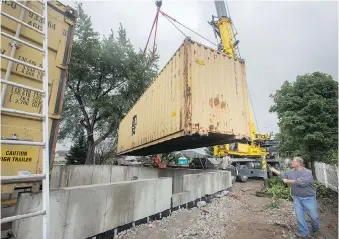  ?? DAX MELMER ?? A crane moves large shipping containers on to a foundation Tuesday for the new lakefront home of Sandor Abri on St. Clair Road in Stoney Point. Abri says the “ready-made house” involves aligning and stacking the containers, welding them together and then cutting out sections for windows and doors.