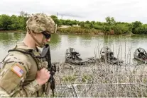  ?? CHENEY ORR / THE NEW YORK TIMES ?? A U.S. National Guardsman patrols on top of shipping containers in Eagle Pass, Texas. The most aggressive state-level immigratio­n law in the nation went into effect briefly in Texas on Tuesday but is now on hold again.