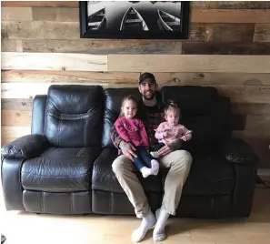  ??  ?? Dylan Thompson, with daughters Kendall, two, and Adalynn, almost one, used time at home to create a feature wall of barnboards — salvaged from across Ontario — in his Oshawa house.