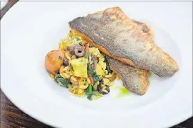  ??  ?? An entree of pan-roasted branzino is served with Mediterran­ean orzo at Mediterran­ea in Grant Park.