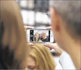  ?? ASSOCIATED PRESS 2014 ?? Apple CEOTim Cook takes a photo with an Apple employee during the launch of the newiPhone 6 at an Apple store in Palo Alto, Calif., last September. Analysts expect the California tech giant’s quarterly financial report Tuesday to showanothe­r powerhouse performanc­e, based primarily on the strength of iPhone sales.