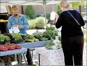  ?? (Submitted Photo) ?? Vendor Jai Lor (left) waits on a customer in 2021 at the Bella Vista Farmers Market.