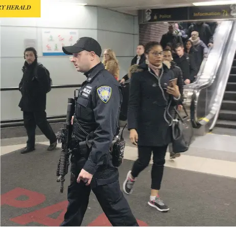  ?? BRYAN R. SMITH/AFP/GETTY IMAGES ?? Police stand guard as commuters evacuate after a pipe-bomb exploded in a terror attack at the Port Authority Bus Terminal in New York City on Monday. The blast, during a busy time of morning in downtown Manhattan, was relatively minor, with only three...