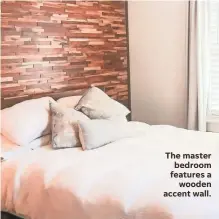  ??  ?? The master bedroom features a wooden accent wall.