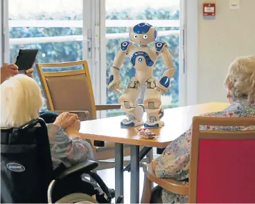  ?? /Reuters ?? Alternativ­es: Elderly people play with a robot named Nao, manufactur­ed by Softbank Robotics. The SoftBank Group has ended talks with Swiss Re, whose traditiona­l reinsuranc­e model has come under pressure in recent years.