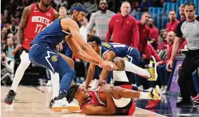  ?? Jack Dempsey/Associated Press ?? Rockets guard Jalen Green, bottom, grabs the ball before the Nuggets’ Zeke Nnaji, left, arrives during the third quarter Monday night.