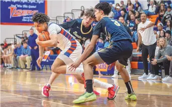  ?? JESSICA BACA/JOURNAL ?? Los Lunas’ Jalin Holland (11) pushes past Santa Fe defenders during Friday night’s game at Los Lunas High School.