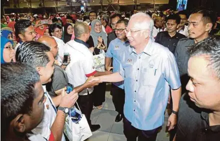  ??  ?? Prime Minister Datuk Seri Najib Razak greeting civil servants during their monthly gathering in Ayer Keroh yesterday. PIC BY KHAIRUNISA­H LOKMAN