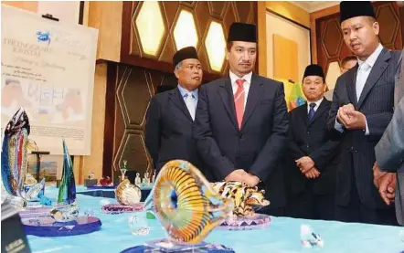  ??  ?? Royal presence: Sultan Mizan listening to Tengku Baharuddin (right) after launching the Silica project and Terengganu Kristal brand programme. With them are Ahmad (left) and Terengganu Industry, Trade and Environmen­t Committee chairman Datuk Toh Chin...