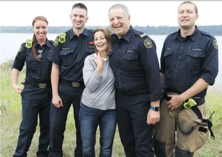  ?? DARREN MAKOWICHUK ?? Capt. Murray Ost and his crew with the Calgary Fire Department are calling Margaret Bell a hero after she rescued a man from the Glenmore Reservoir early on Tuesday. Bell will be considered for the department’s Beyond the Call award program.