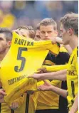  ?? FOTO: DPA ?? Dortmunds Spieler halten ein Trikot Marc Bartras hoch.