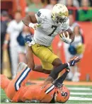  ?? ADRIAN KRAUS/AP ?? Notre Dame running back Audric Estime (7) runs over Syracuse linebacker Alijah Clark (5) during a game Oct. 29. Estime leads the Fighting Irish with nine rushing touchdowns this season.