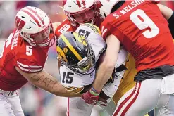  ?? ANDY MANIS/ASSOCIATED PRESS ?? Wisconsin has the nation’s best run defense by a long shot. Linebacker­s Leo Chenal (5) and Nick Herbig (19), and safety Scott Nelson (9), wrap up Iowa running back Tyler Goodson (15) in action from Oct. 30.