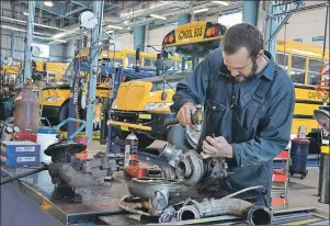  ?? LAURA JEAN GRANT/CAPE BRETON POST ?? Jason Covey, a mechanic at the Cape Breton-Victoria Regional School Board’s transporta­tion and maintenanc­e facility in Sydney, inspected a turbo charger, Tuesday. Staff at the facility are busy getting close to 100 buses ready for the new school year.