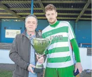 ??  ?? Lochee captain Greig Cushnie is presented with the trophy by league president Rory Malone.