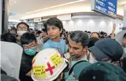  ?? Picture: ANTHONY KWAN/GETTY IMAGES ?? A WAY THROUGH: Protesters allow a UK family of four to go through the departure gate during the blockage at Terminal 2 of the Hong Kong Internatio­nal Airport
