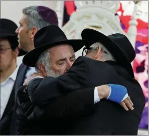  ?? AP/GREGORY BULL ?? Rabbi Yisroel Goldstein (left) hugs an attendee at Monday’s funeral for Lori Kaye, who was killed Saturday when a gunman opened fire inside a synagogue in Poway, Calif. Goldstein lost a finger in the shooting.