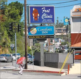  ?? Photograph­s by Gary Coronado Los Angeles Times ?? SUNSET FOOT Clinic in Silver Lake has a revolving sign with a cartoonish drawing of a mournful foot character clinging to crutches on one side; the reverse side features a limber, smiling foot.