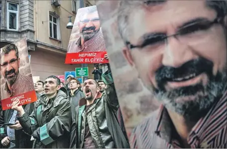  ?? Ozan Kose AFP/Getty Images ?? DEMONSTRAT­ORS in Istanbul, Turkey, last month carry signs bearing the image of slain human rights attorney Tahir Elci.