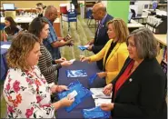  ?? SUBMITTED PHOTO ?? Pictured, right, background to foreground: Chester County Commission­ers Terence Farrell, Michelle Kichline and Kathi Cozzone meet with county residents to hand out doses of Naloxone at the Chester County Library, during Naloxone Giveaway Day.