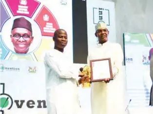  ??  ?? The Chairman, Kaduna Electric, Yusuf Hamisu Abubakar (right), presents an award to Governor Nasir El-Rufai who was represente­d by the state commission­er for commerce, Dr. Manzo Daniel Maigari, at the Innovation roundtable for start-ups and...