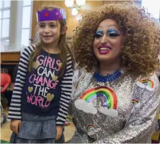  ?? MARY ALTAFFER/AP ?? Lil Miss Hot Mess poses for a photo with a child after reading to a group of children during the Feminist Press’ presentati­on of Drag Queen Story Hour! at the Park Slope Branch of the Brooklyn Public Library, in New York.