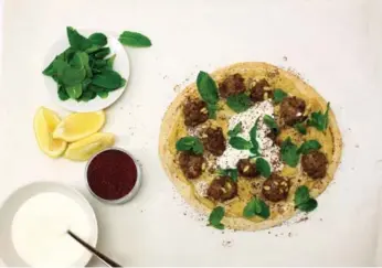  ?? COLE BURSTON/TORONTO STAR ?? Australian food personalit­y Donna Hay is devoted to getting people to cook at home. She made this spiced lamb and hummus pita in the Star test kitchen. It’s topped with fresh mint, sumac, yogurt and fresh lemon.