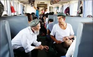  ?? WANG ZHUANGFEI / CHINA DAILY ?? Passengers chat during the 28.5-hour journey from Urumqi to Hotan.