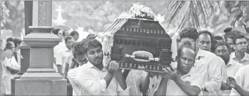  ??  ?? Relatives are seen carrying the coffin of a bomb blast victim for a burial ceremony at a cemetery in Colombo. — AFP photo