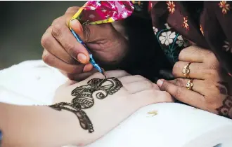  ??  ?? A henna artist at work during GlobalFest. The painting can last anywhere from between one to four weeks.