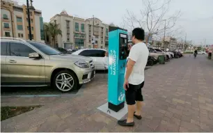  ?? Photo by Ryan Lim ?? A man uses a parking machine at the Town Centre in Al Ain Eastern Region. —