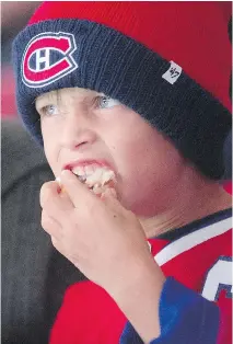  ?? PIERRE OBENDRAUF/MONTREAL GAZETTE ?? Alexis Sauve, 6, keeps his eye on the game and his hand in his cotton candy at the Canadiens’ scrimmage.