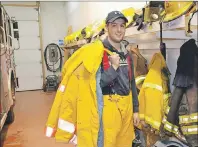  ?? ERIC MCCARTHY/JOURNAL PIONEER ?? West Point Volunteer Fire Department member Zach Stewart tries on one of the 20 new sets of bunker gear the department recently purchased. They also purchased new pagers. The department relies heavily on fundraisin­g activities for its equipment...