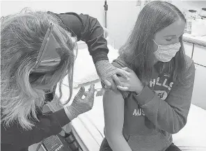  ?? CINCINNATI CHILDREN’S HOSPITAL ?? Katelyn Evans, 16, gets the first of two shots as part of a trial testing of Pfizer’s COVID- 19 vaccine in minors.