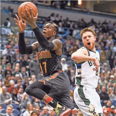  ?? BENNY SIEU / USA TODAY SPORTS ?? Hawks guard Dennis Schroder gets by Bucks guard Matthew Dellavedov­a for a shot in the third quarter Friday. Schroder scored 33 points.