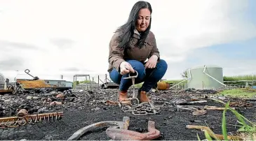  ??  ?? Owner Brittany Willis inspects the ashes of the fire which destroyed an estimated $30,000 of horse gear and equipment at Branxholme recently. ROBYN EDIE/STUFF