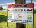  ?? ALLEN EYESTONE / THE PALM BEACH POST ?? A Martin County Health Department sign warns to avoid contact with algae near the Port Mayaca locks.