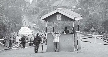  ?? — AFP photo ?? A Ugandan police officer stands guard at the Mpondwe check point at the border with Democratic Republic of Congo near Kasese district, about 340 kilometres west of the capital Kampala. Countries in Africa’s Great Lakes region launched an intelligen­ce...